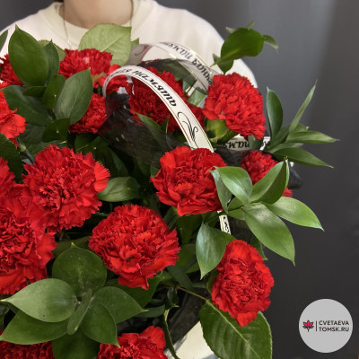 Траурная корзина с красными гвоздиками и зеленью